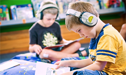Two students reading with headphones.